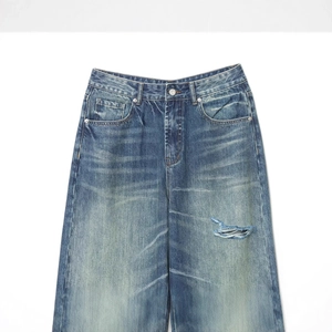 Mid-waist loose fit distressed denim jeans in dark blue with ripped details and rolled cuffs