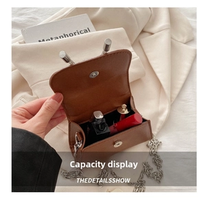 Detail view of brown patent leather crossbody bag interior showing lipstick storage capacity