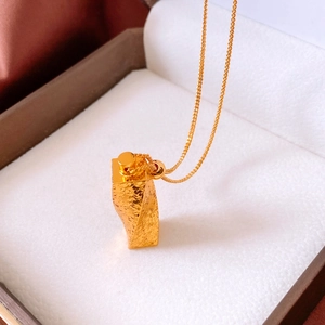 Close-up of a 24k gold plated twisted bar pendant necklace with a hammered texture finish