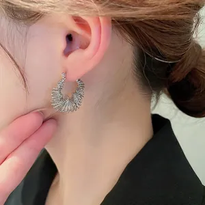 Irregular geometric spiral hoop earrings in silver finish for a modern minimalist style
