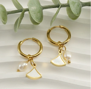 Detail of gold titanium steel hoop earrings with shell fan pendant and natural pearl charm