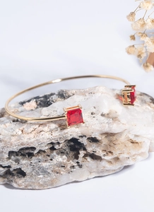 Detail of 18K gold adjustable cuff bracelet with dual square red zircon stones