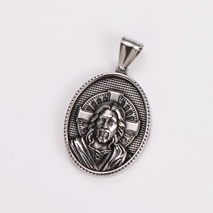 Close-up of oval silver pendant featuring Jesus relief and cross on stainless steel necklace
