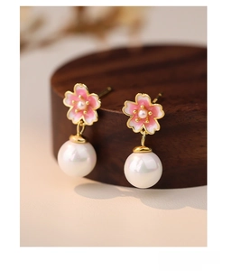 Macro shot of S999 sterling silver pink cherry blossom earrings with elegant pearls