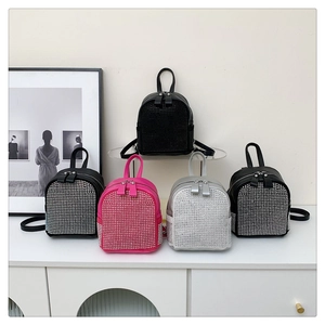 Macro shot of stylish rhinestone mini backpacks in black, rose, and silver finishes