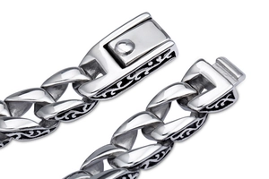 Macro view of stainless steel men's bracelet featuring vintage engraved link patterns