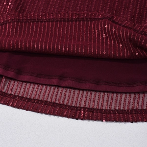 Detailaufnahme von burgunderrotem Paillettenstoff mit hochwertiger Netzschicht am Kleid