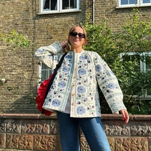 Detailed view of quilted cotton jacket with blue and purple floral embroidery details