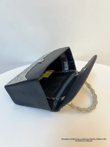 Macro shot of trapezoid black evening clutch bag with rhinestones and metal chain