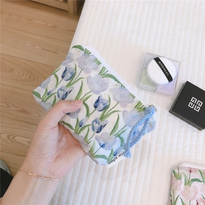 Close-up of small floral cotton pouch featuring blue tulip prints and simple wish label