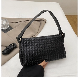 Détail du sac à main noir tressé avec boucle dorée et bandoulière amovible incluse