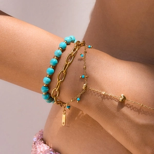 Detail of luxury tiger eye and turquoise beaded bracelet set with gold heart pendant