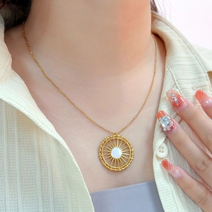 Détail du collier avec pendentif soleil plaqué or 18K et pierre blanche sur peau
