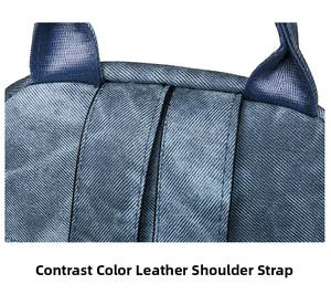 Detail of dark blue backpack showing reinforced stitching and contrast leather shoulder straps