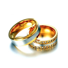 Close-up of dual-tone couple rings with brushed finish and inlaid sparkling crystals