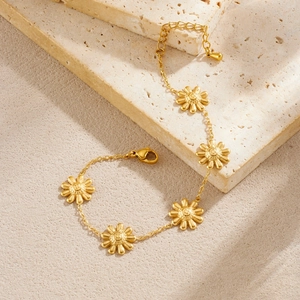 Gold plated stainless steel chain bracelet featuring five daisy flower charms and lobster clasp
