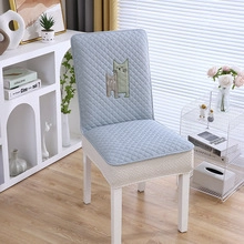 Detail of light blue quilted chair cover featuring cute embroidered cartoon cats on back