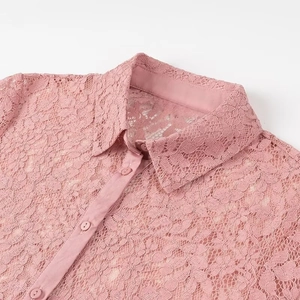 Close-up of pink lace polo shirt collar with buttons and floral pattern detail
