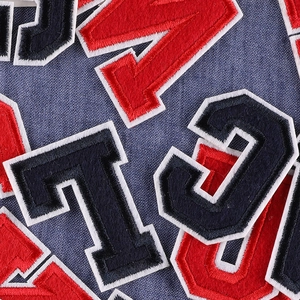Embroidered strawberry letter patches for DIY clothing decoration on denim background