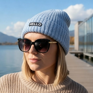 Détail de la broderie HELLO sur un bonnet en maille bleu clair pour l'hiver