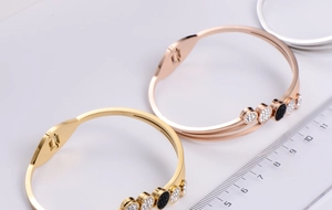 Detailed view of three-layer rhinestone bangles with black disc in gold and silver