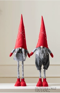 Detail of red and grey plush Christmas gnomes with telescopic legs and star embroidery