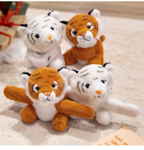 Detailed view of soft plush tiger wristbands in white and yellow on a textured carpet