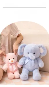 Close-up of plush teddy bear and elephant toys with plaid bows in a cozy home setting