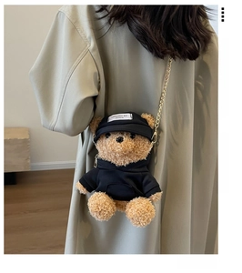 Detail der Teddybär-Plüschtasche mit schwarzem Hoodie und goldener Metallketten-Schultergurt