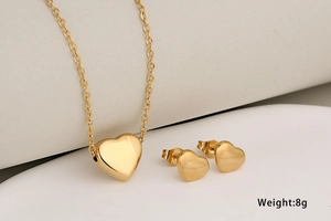 Polished gold heart necklace and earring set on white background weighing 8g