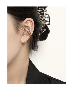 Detail view of S925 sterling silver hoop earrings and irregular metal hair claw on a model