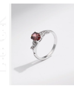 Macro shot of S925 sterling silver ring with oval red gemstone and hollow floral patterns