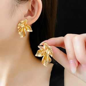 Vue détaillée des boucles d'oreilles pétales dorés avec couches de fleurs métalliques