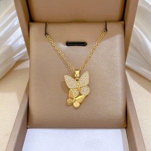 Detailed macro of gold double butterfly necklace with sparkling zircon pavé on velvet