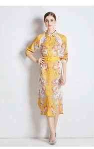Detail of yellow floral dress with shirt collar, buttoned front, and matching waist belt