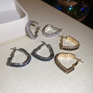 Macro display of sparkling heart-shaped hoop earrings with colorful zircon inlay details