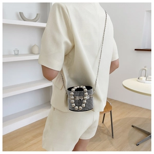 Detail of cylinder handbag with silver rhinestones and large metal bead handle