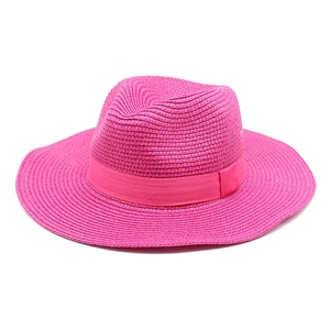 Detail of rose pink woven straw fedora hat with matching ribbon for summer sun protection