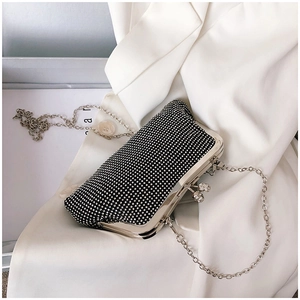 Macro detail of sparkly black evening clutch with silver frame and crystal ball clasp
