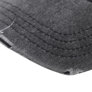 Detailed macro shot of a charcoal gray cotton baseball cap brim with distressed vintage wear
