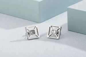Detailed close-up of square hollow silver earrings with sparkling cubic zirconia stone