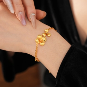 Detail of vintage gold plated flower bracelet featuring matte petals on model wrist