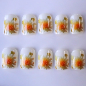 Short square press-on nails with white base and orange floral daisy pattern gloss finish