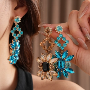 Gros plan de boucles d'oreilles vintage en forme de fleur avec cristaux ambre et bleus