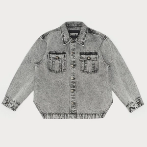 Detail of grey acid wash denim shirt showing dual chest pockets and metal buttons