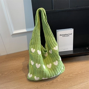 Green handmade knit tote bag with white hearts and thick cable stitch texture