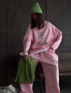 Detail of pink leisure tracksuit with striped stitching and printed sweatshirt logo