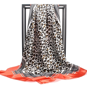 Detail of satin leopard print scarf featuring red borders and geometric wave patterns