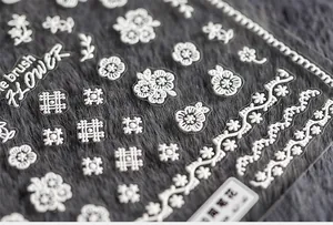 Macro detail of white 3D floral nail art stickers with delicate lace patterns