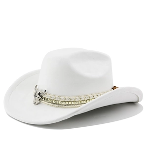 Detail of white suede cowboy hat featuring a silver bull head buckle and gold braided band